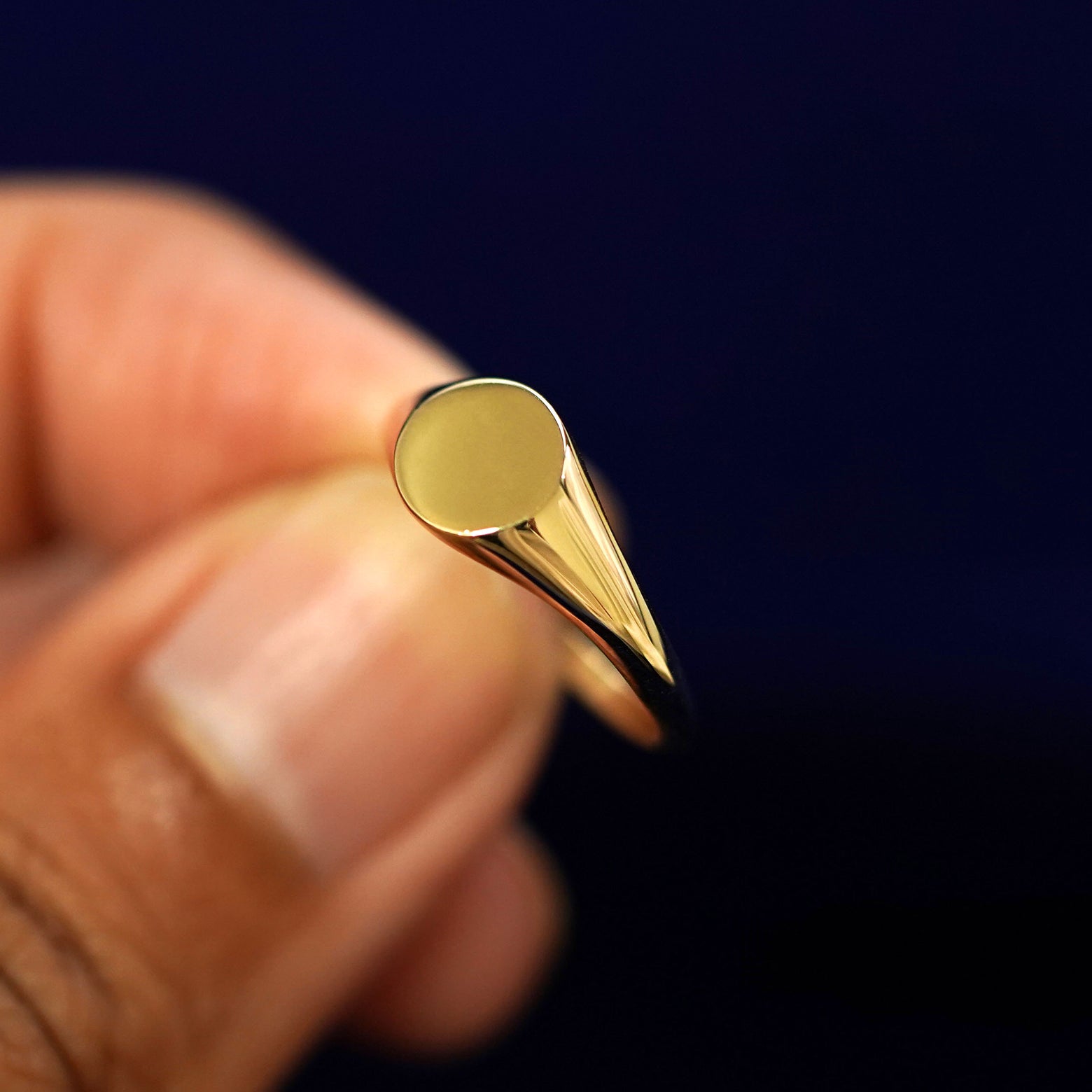 A model holding a Signet Ring tilted to show the side of the ring