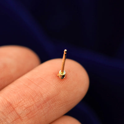 A 2mm Diamond Earring facedown on a model's fingertip to show the back of the stud