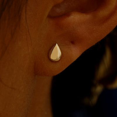 Close up view of a model's ear wearing a yellow gold Teardrop Earring