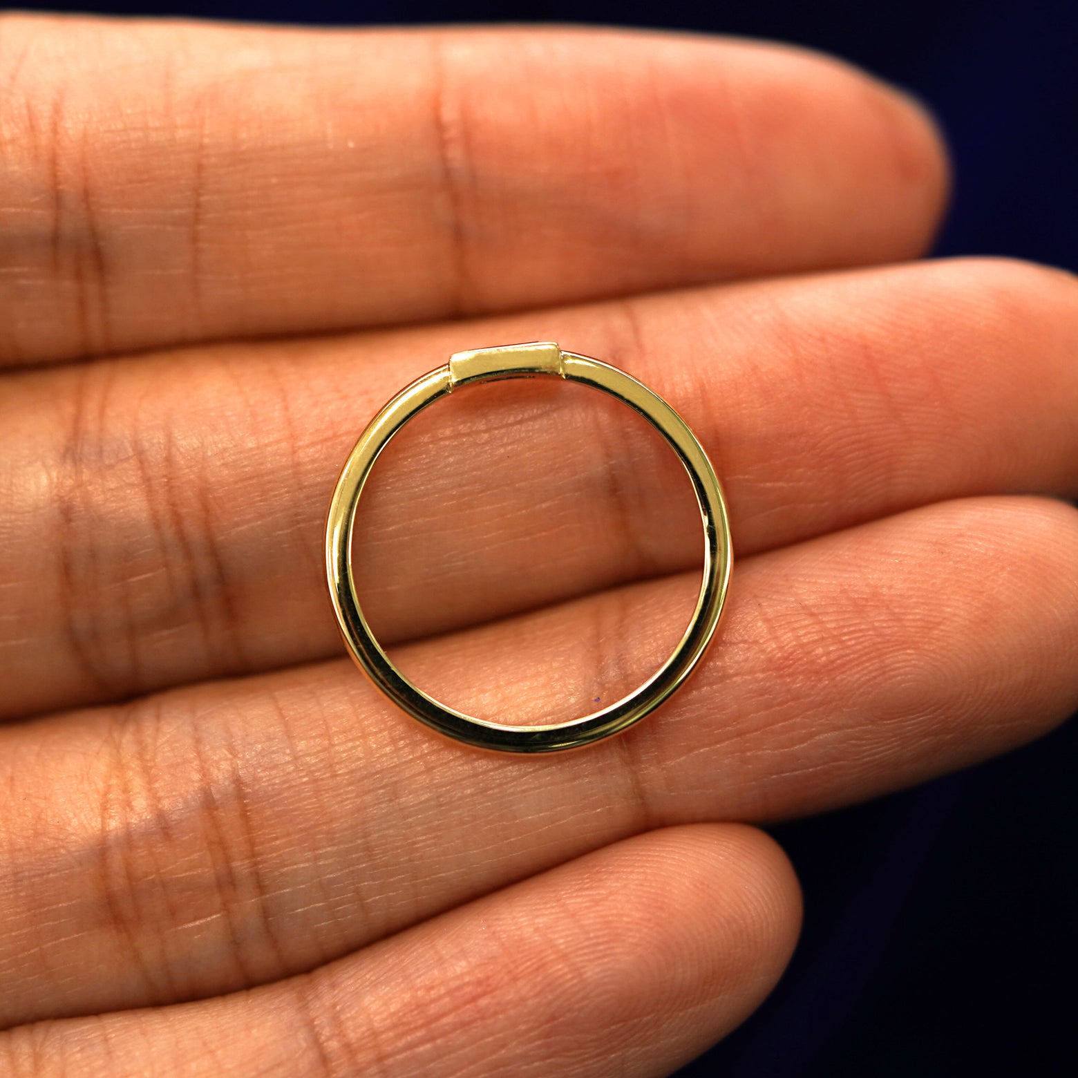 A yellow gold Baguette Salt and Pepper Diamond Ring in a model's hand showing the thickness of the band