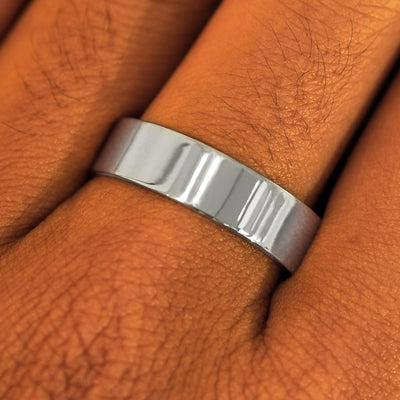 Close up view of a model's fingers wearing a 6mm 950 platinum Industrial Mirror Band