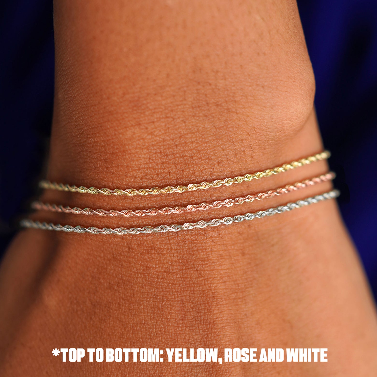 Close up view of a model's wrist wearing a three  versions of the Rope Anklet in yellow, rose, and white gold