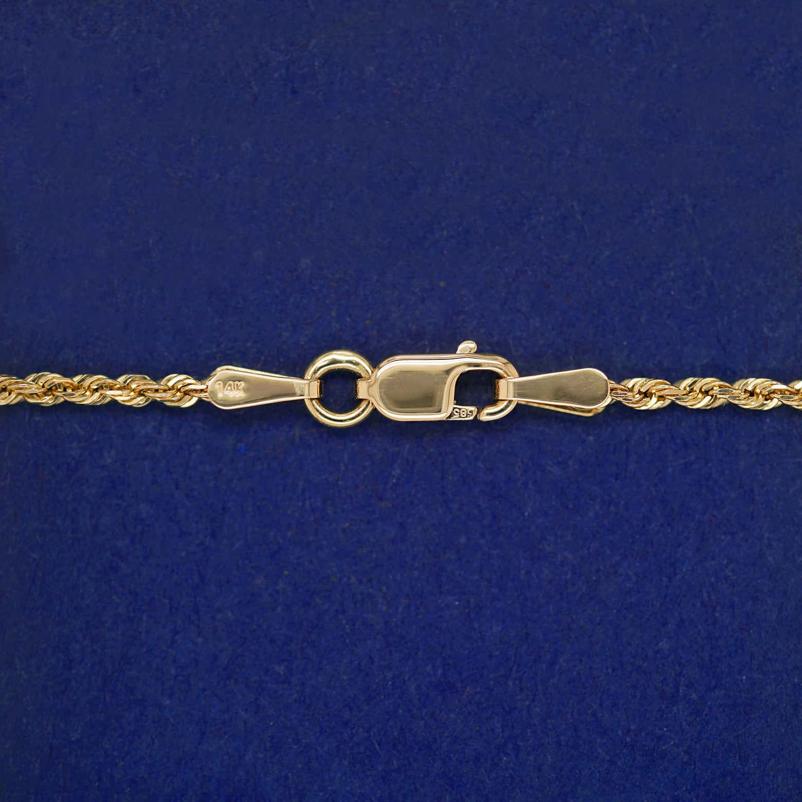 Close up view of a lobster claw clasp on a yellow gold Rope Chain 