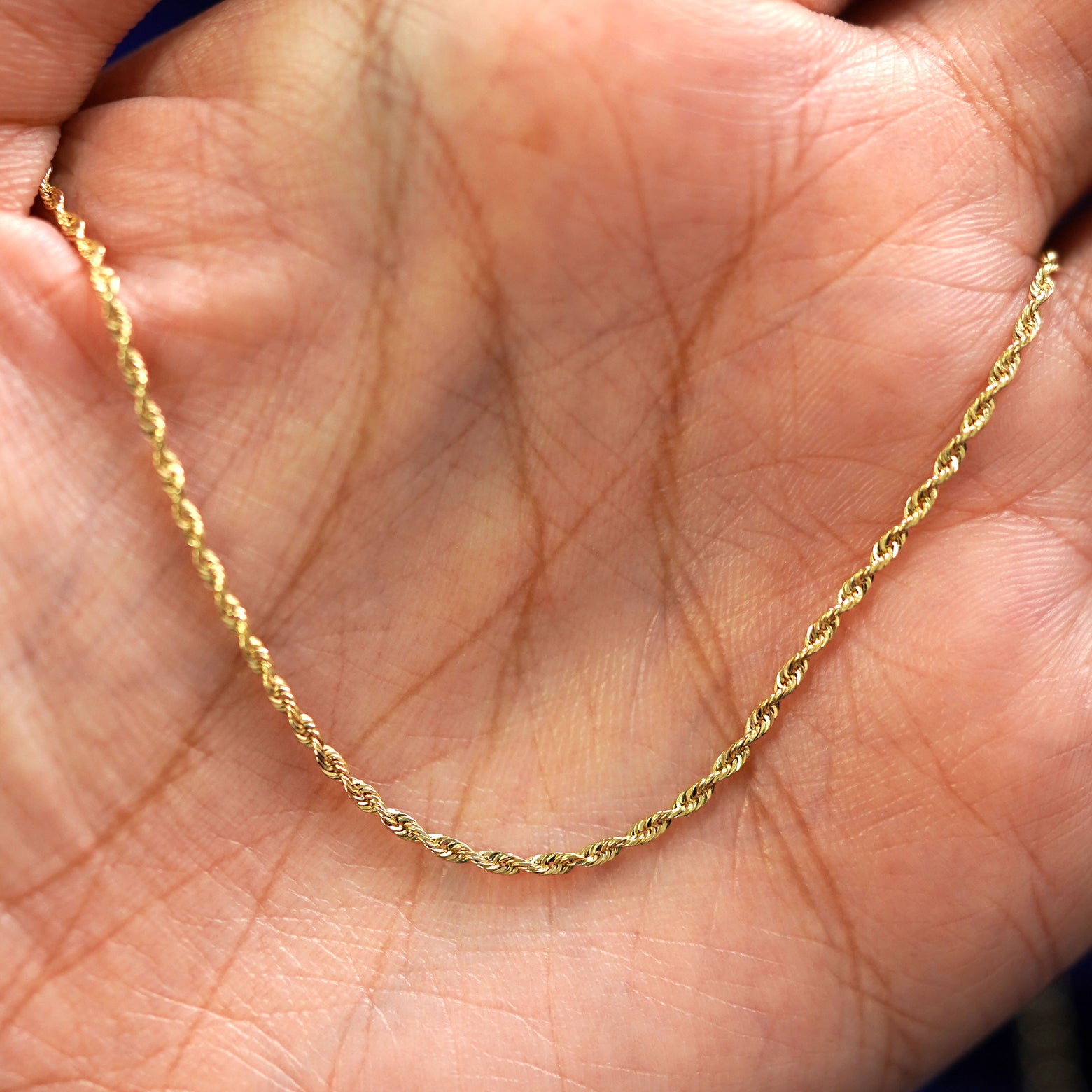 A yellow gold Rope Chain draped on a model's palm