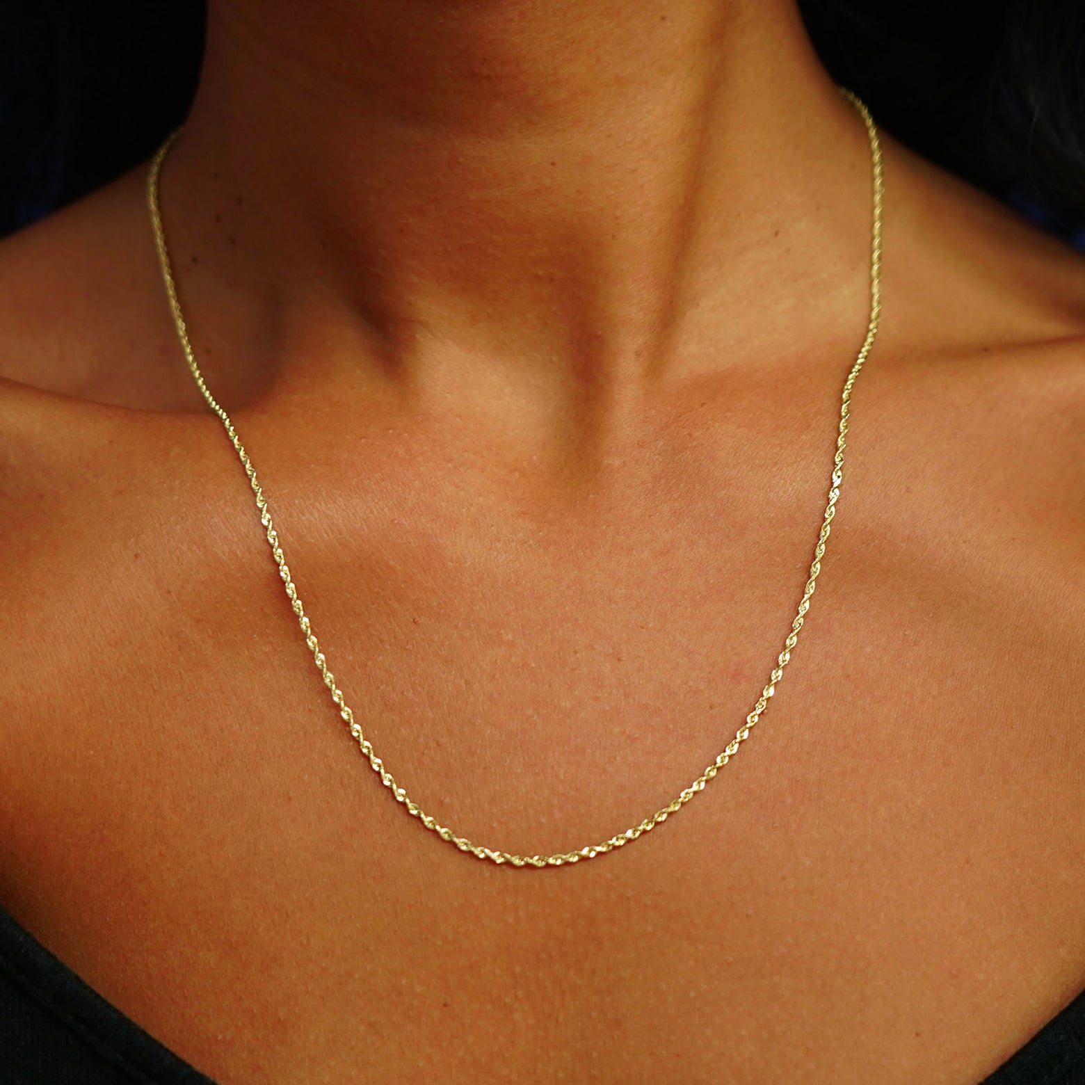 Close up view of a model's neck wearing a solid 14k yellow gold Rope Chain