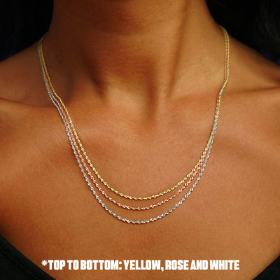 Close up view of a model's neck wearing a three  versions of the Rope Chain in yellow, rose, and white gold