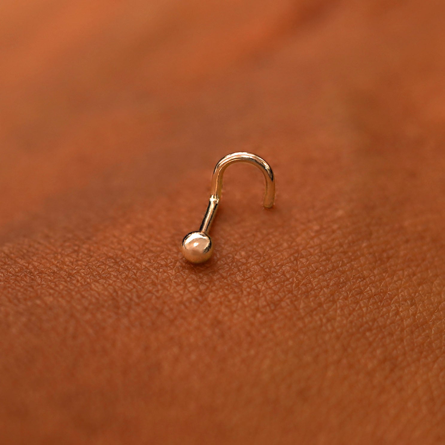 A rose gold Ball Nose Stud laying on the back of a model's hand