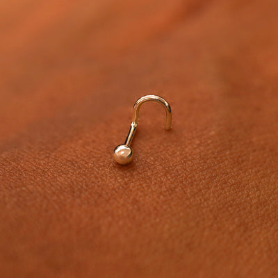 A rose gold Ball Nose Stud laying on the back of a model's hand