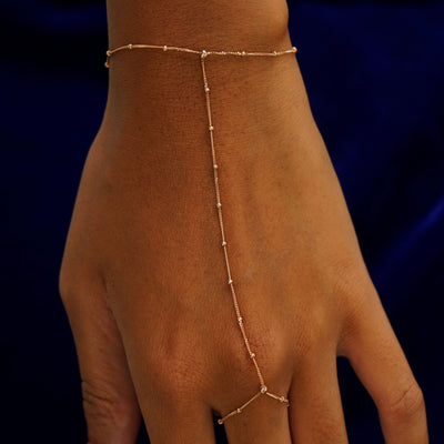 Close up view of a model's wrist wearing a rose gold Beaded Essential Hand Bracelet