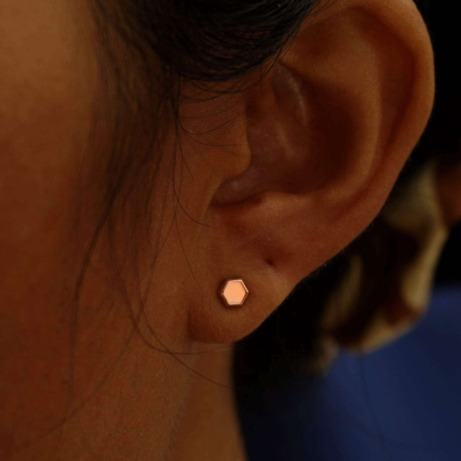 A model's ear wearing a 14k rose gold Hexagon Earring