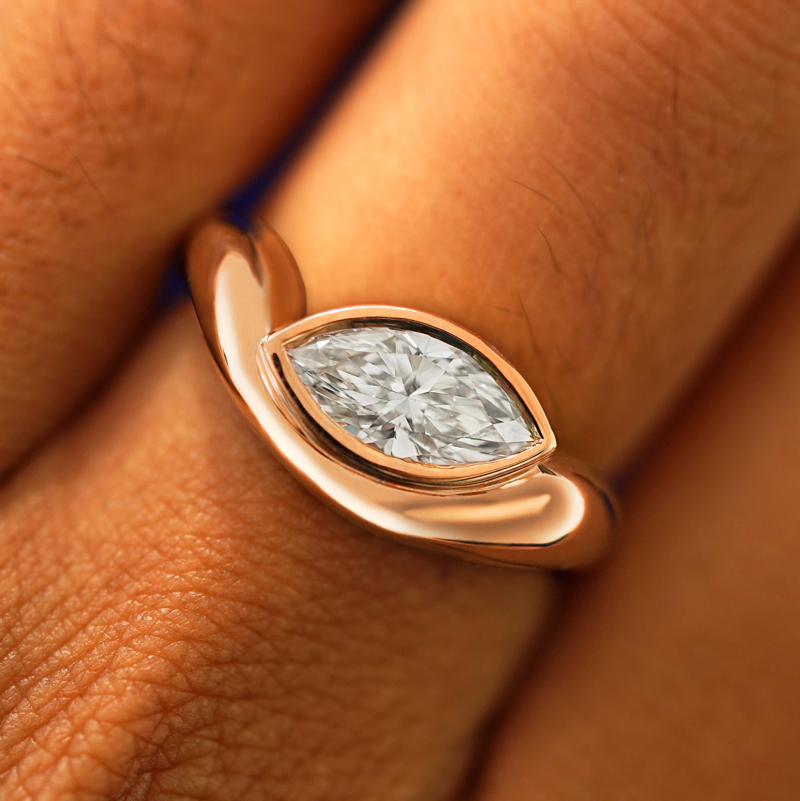 Close up view of a model's fingers wearing a 14k rose gold Marquise Lab Diamond Melted Ring