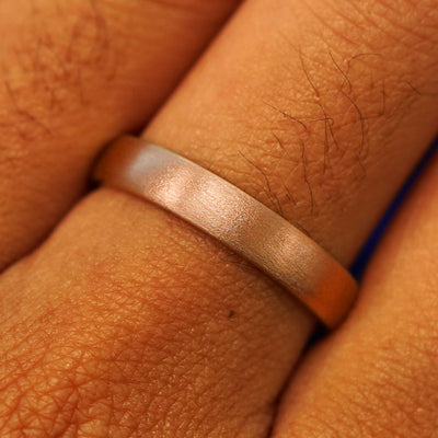 Close up view of a model's fingers wearing a 14k rose gold Mix Matte Band