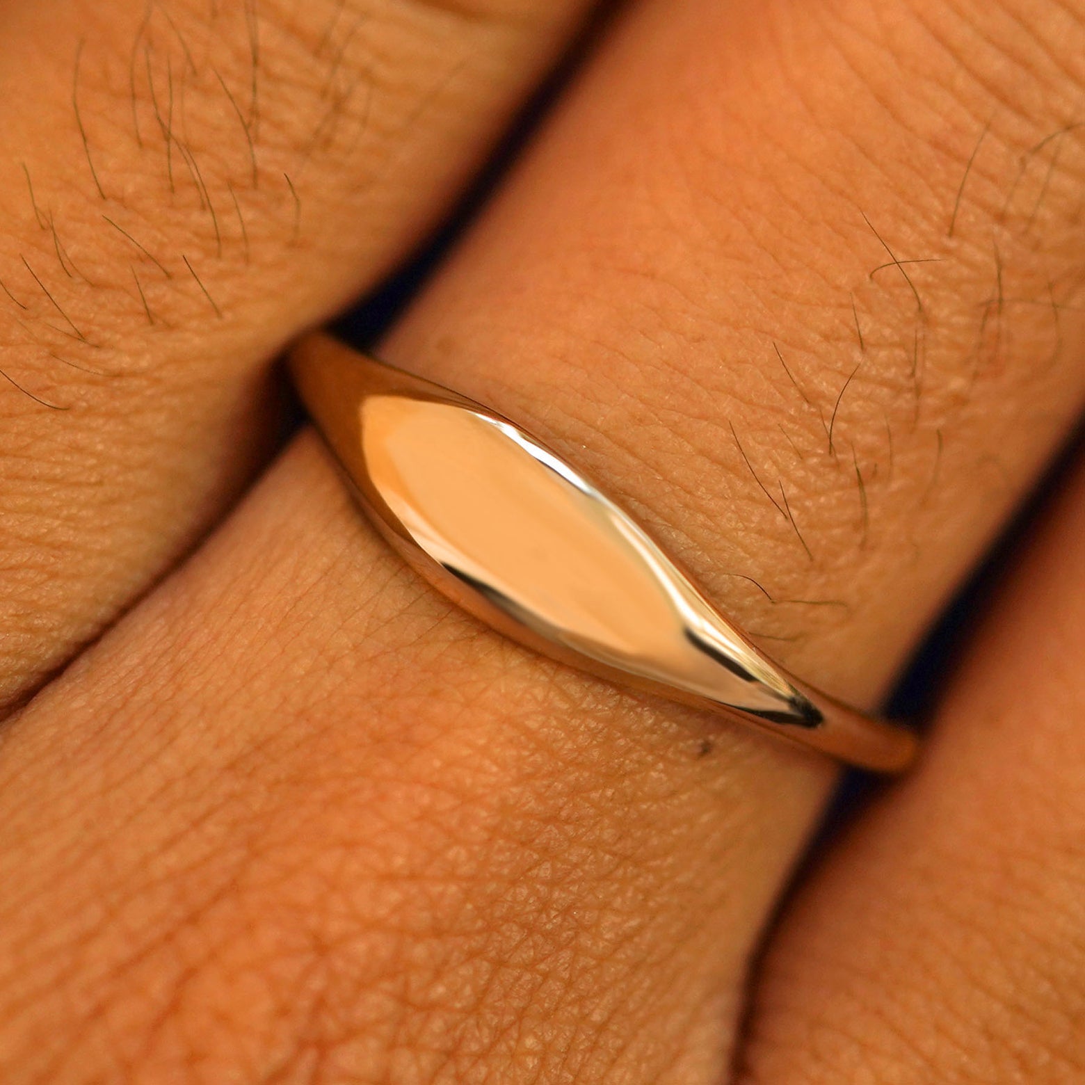 Close up view of a model's fingers wearing a 14k rose gold Puffy Elongated Signet Ring