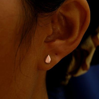 A model's ear wearing a 14k rose gold Teardrop Earring