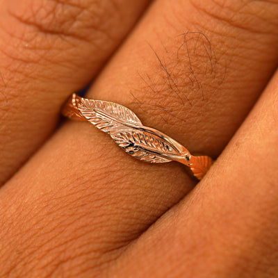 Close up view of a model's fingers wearing a 14k rose gold Thick Leaves Band