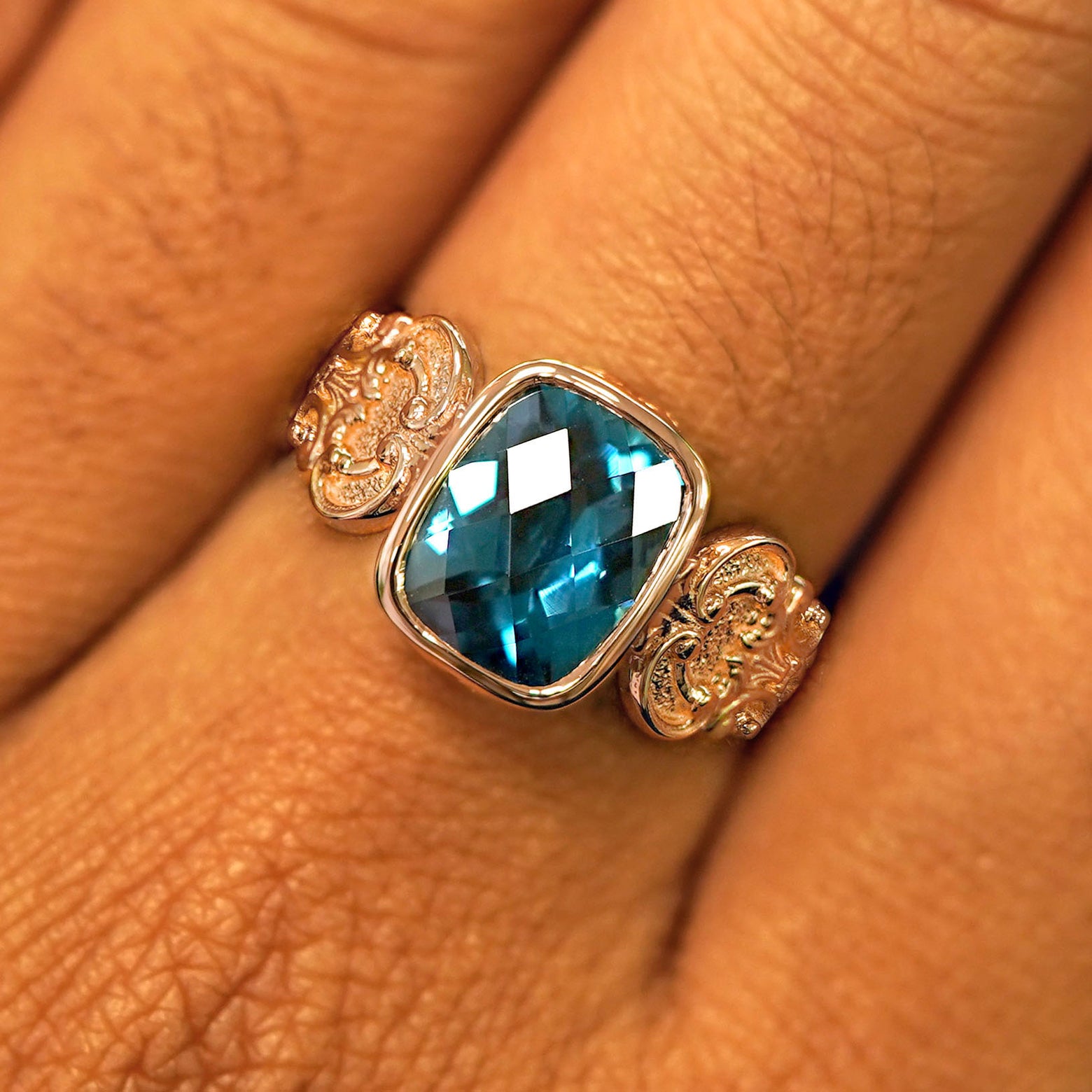 Close up view of a model's fingers wearing a rose gold London blue topaz Royalty Ring