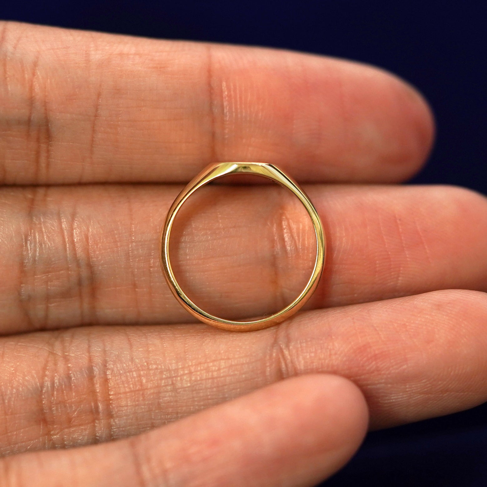 A yellow gold Diamond Signet Ring in a model's hand showing the thickness of the band
