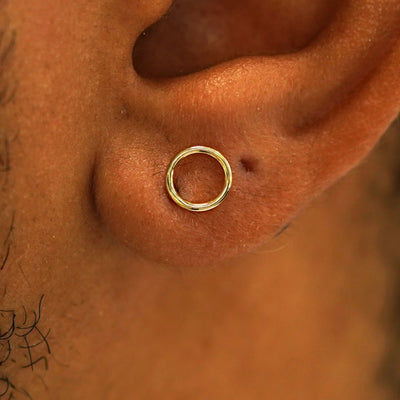 Close up view of a model's ear wearing a 14k gold Open Circle Earring