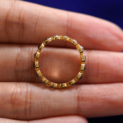 A yellow gold Milgrain Diamond Band in a model's hand showing the thickness of the band