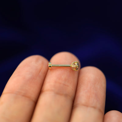 Side view of a yellow gold Salt and Pepper Diamond Flatback Piercing on a model's fingertips