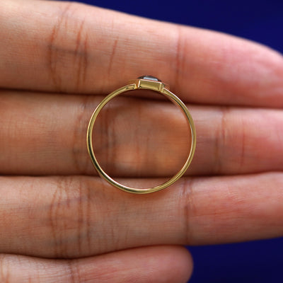 A yellow gold Hexagon Diamond Band in a model's hand showing the thickness of the band
