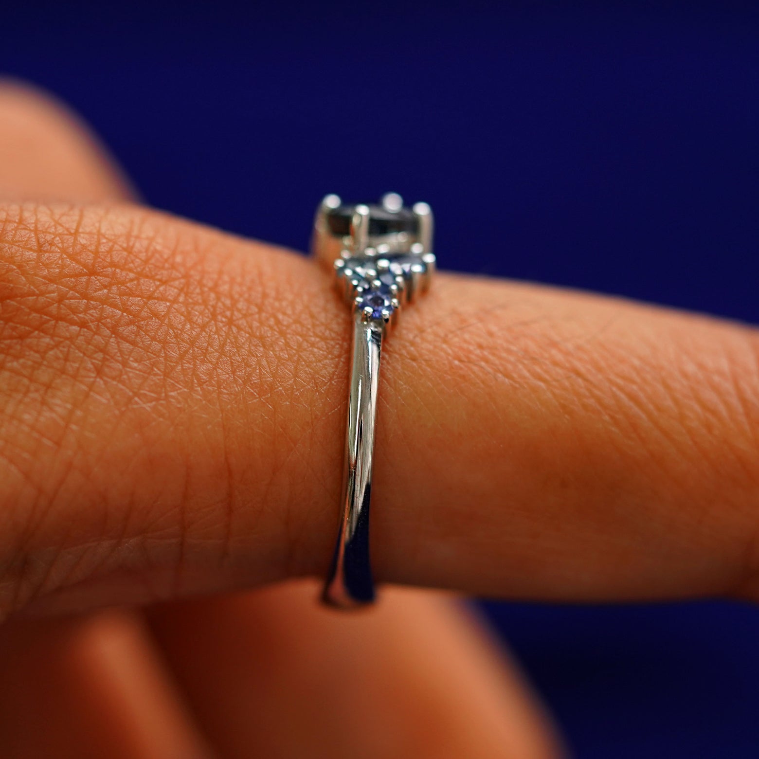 Side view of a Sapphire Cluster Ring on a model's finger