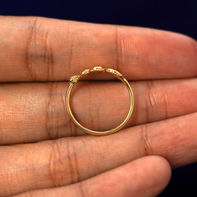 A yellow gold Snake Ring in a model's hand showing the thickness of the band