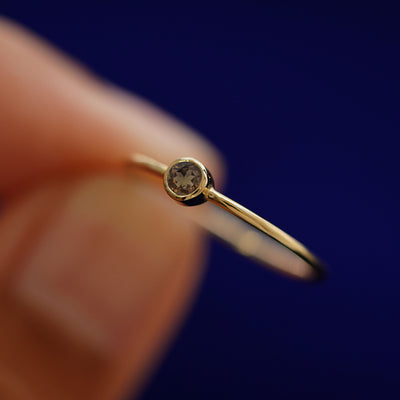 A model holding a Smoky Quartz Ring tilted to show the bezel setting