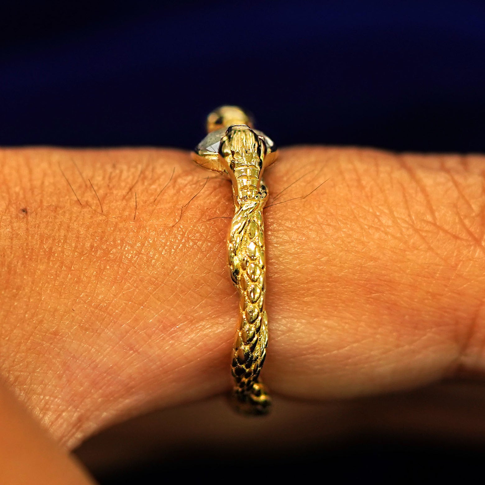 Side view of a Guardian Snakes Ring on a model's finger to show details