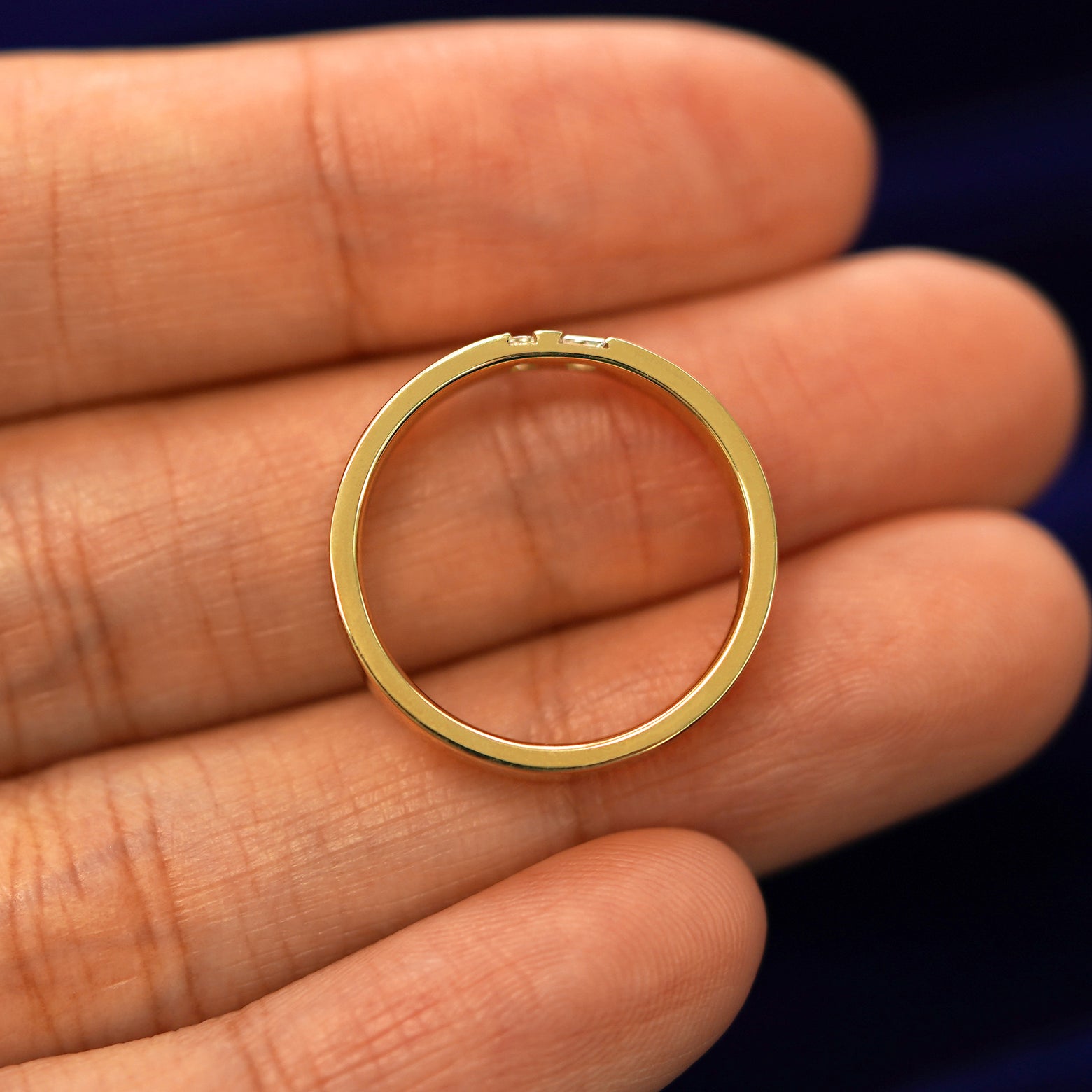 A yellow gold Double Baguette Diamond Band in a model's hand showing the thickness of the band