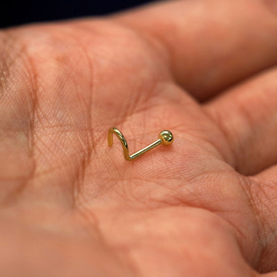 A model's palm holding a Ball Nose Stud to show the details of the screw