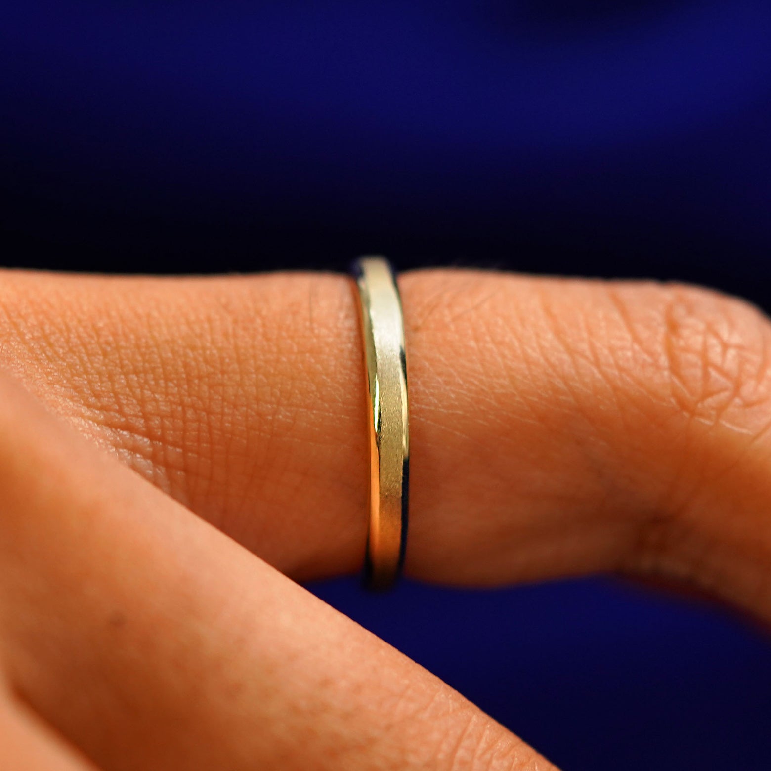 Side view of a Beveled Edge Band on a model's finger