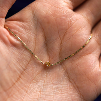 A yellow gold Citrine Bracelet draped on a model's palm