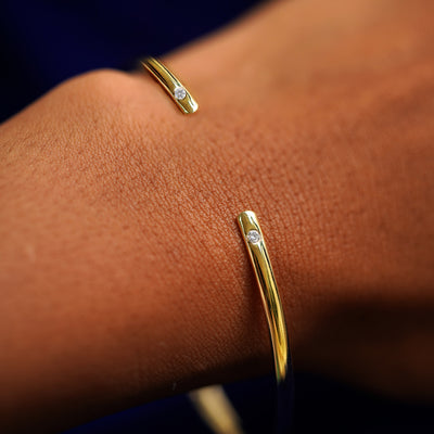 A model's wrist wearing a yellow gold Diamond Open Bangle Bracelet