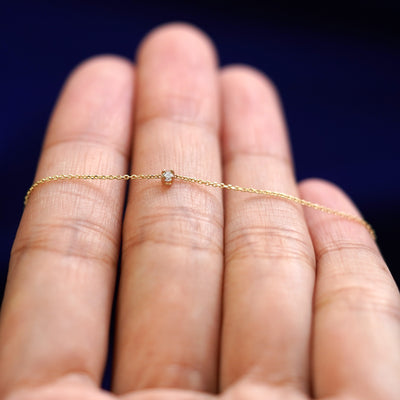 A yellow gold Diamond Cable Necklace resting on a model's fingers