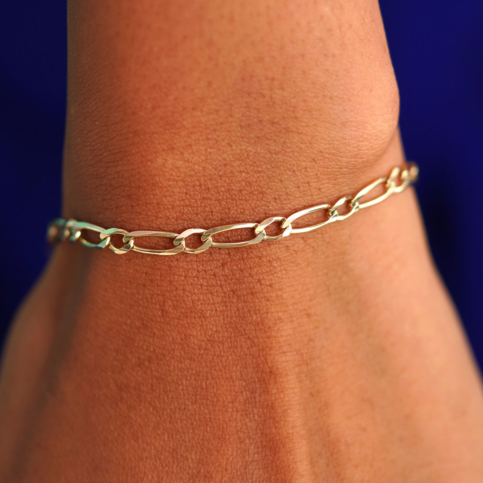 A model's wrist wearing a yellow gold One to One Chain Bracelet