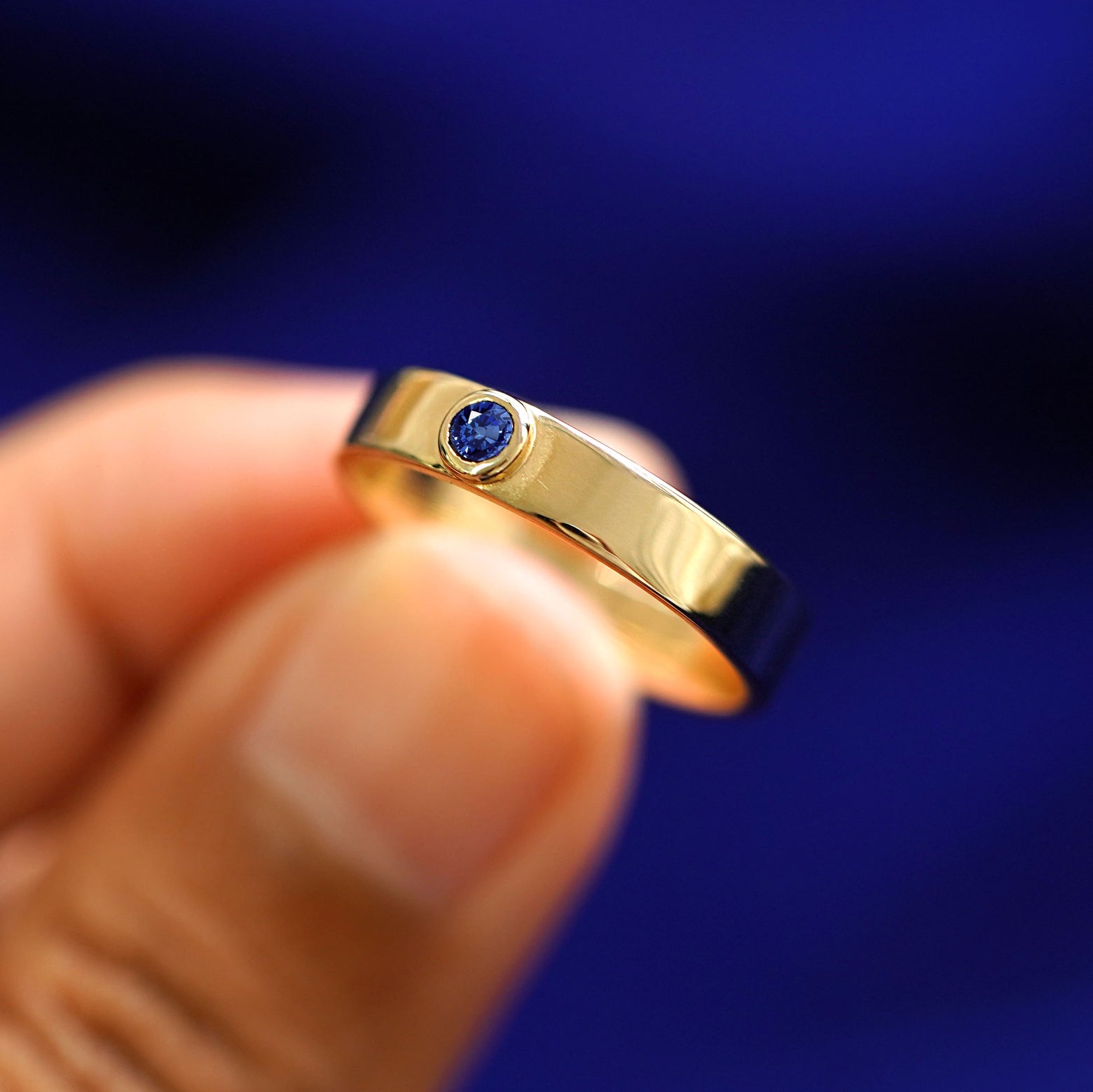 A model holding a sapphire Gemstone Industrial Band tilted to show the side of the ring