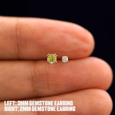 A model holding a 3mm Gemstone Earring and a 2mm Gemstone Earring between their fingers