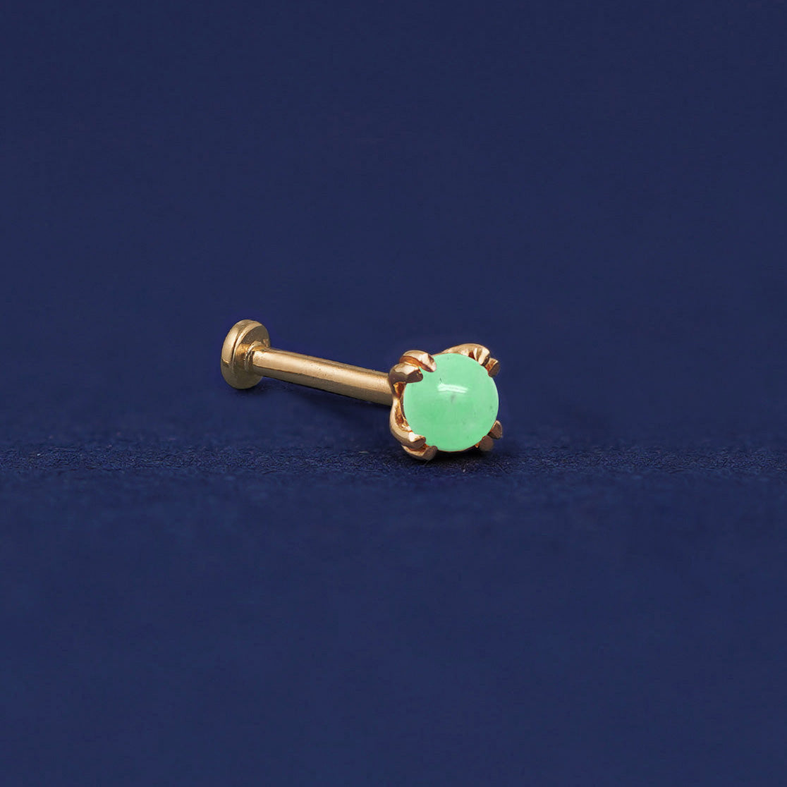 A 14 karat solid gold Green Jade Flat Back Earring on a dark blue background