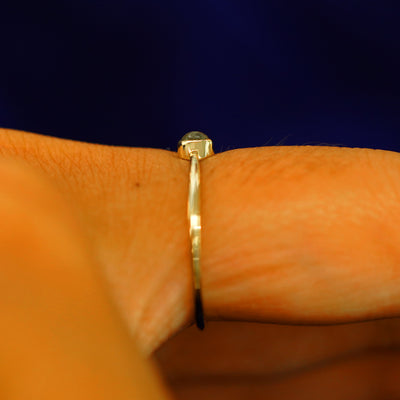 Side view of a solid gold Labradorite Ring on a model's finger