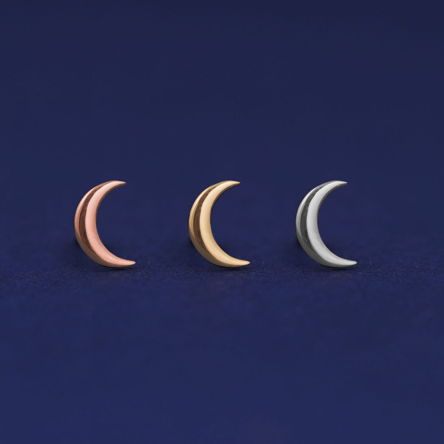 Three versions of the Moon Earring shown in options of yellow, white, and rose gold