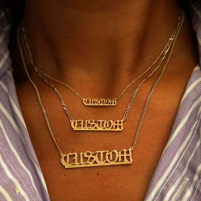 A model's neck wearing a Small Custom Nameplate, Medium Custom Nameplate, and Large Custom Nameplate layered