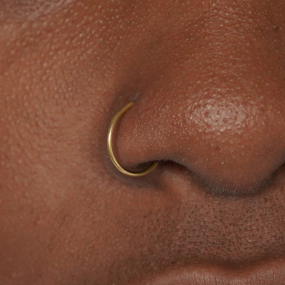 Close up view of a model's nose wearing a yellow gold Nose Ring Hoop