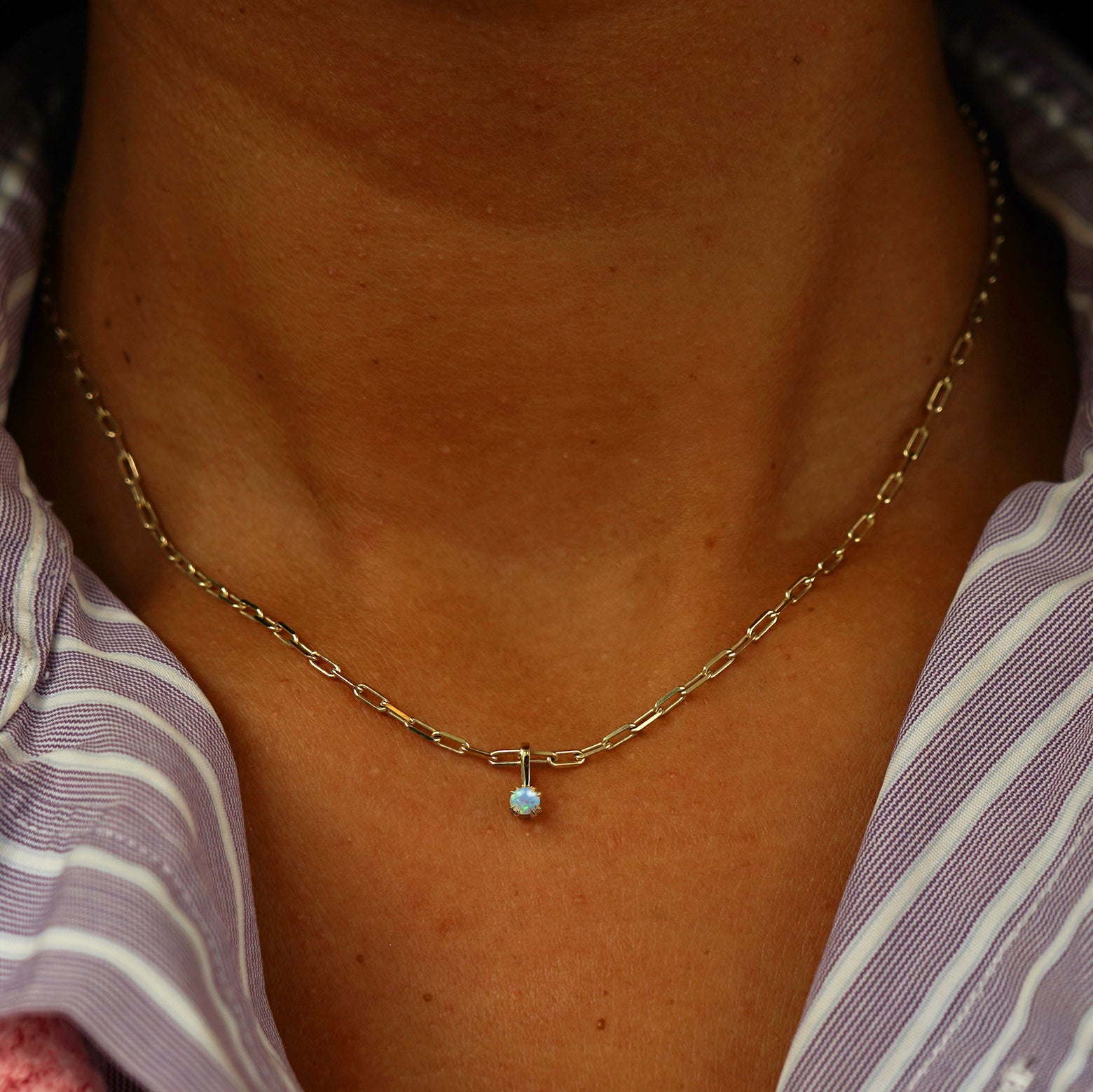 Close up view of a model's neck wearing a yellow gold Opal Charm on a Butch Chain