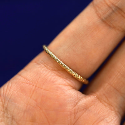 Close up view of the underside of a model's hand wearing a 14k yellow gold Ouroboros Snake RIng