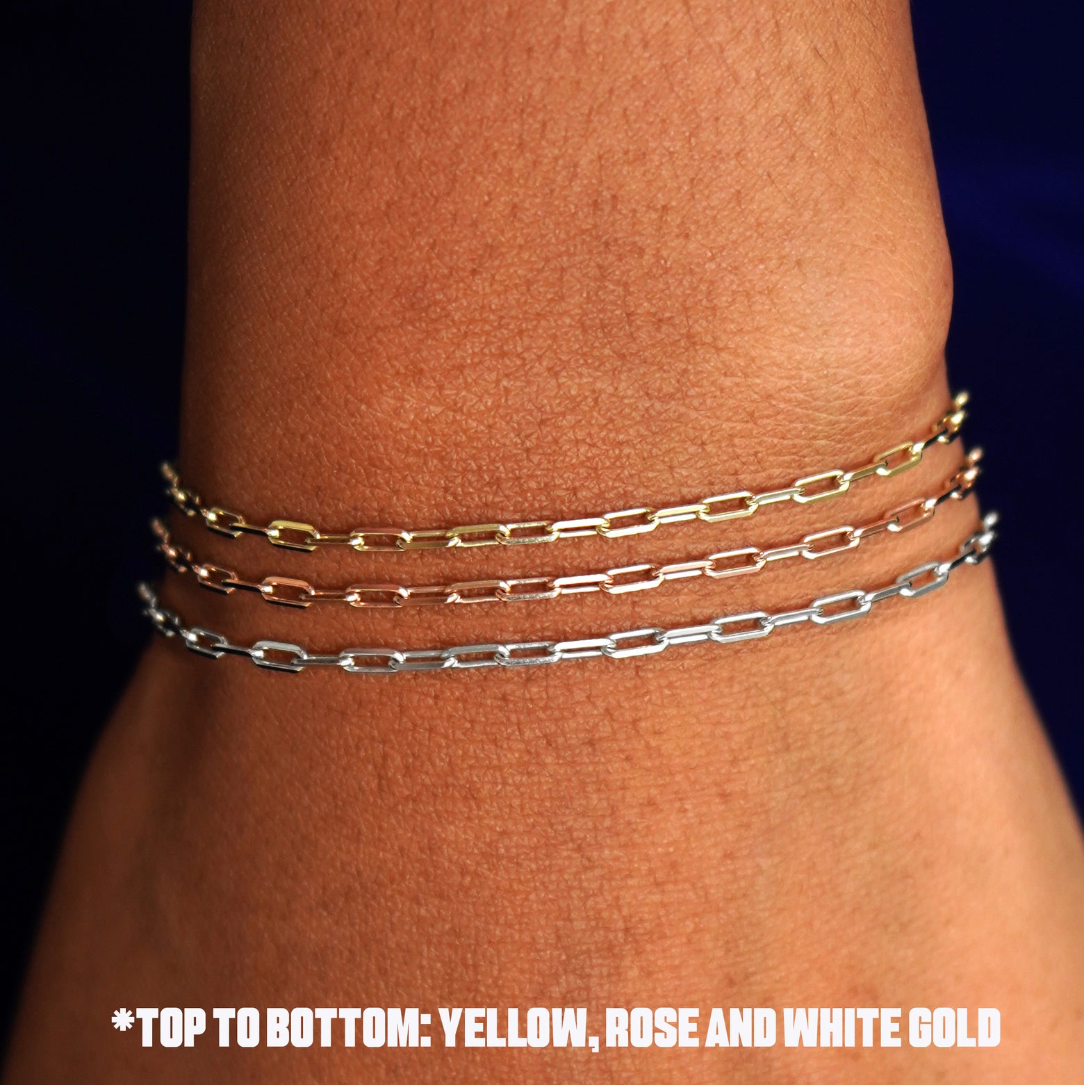 Close up view of a model's wrist wearing three versions of the Butch Anklet in yellow, white, and rose gold