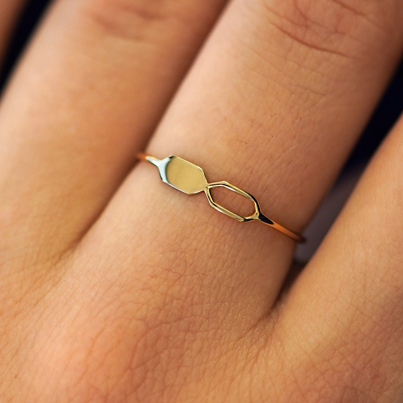 Close up view of a model's fingers wearing a 14k yellow gold Tanlah Ring