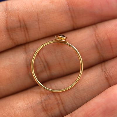 A yellow gold Coffee Cup Ring in a model's hand showing the thickness of the band