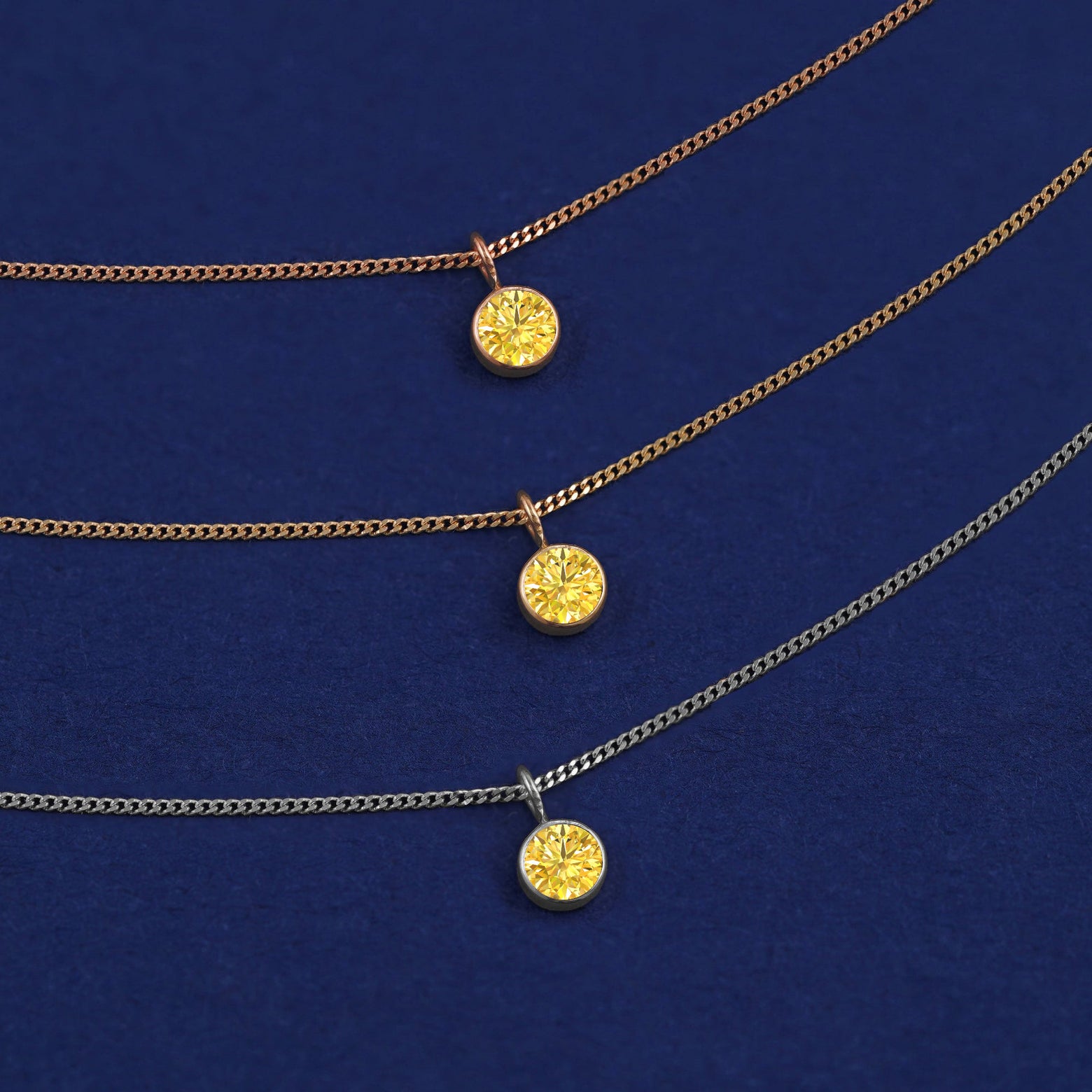 Three versions of the Yellow Diamond Necklace in options of yellow, white, and rose gold on a dark blue background