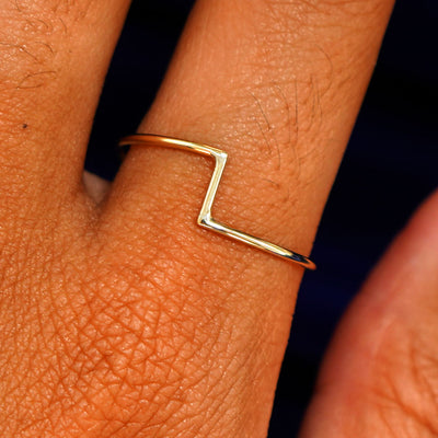 Close up view of a model's fingers wearing a 14k yellow gold Zig Zag Ring